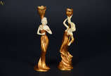 Duas figuras femininas em forma de castiçais em... - Duas figuras femininas em forma de castiçais em resina dourada