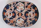 Porcelana Imari (1653),  - Travessa de porcelana japonesa Imari, feitio oval, trabalhos canelados em relevo, parte posterior com desenhos em azul.