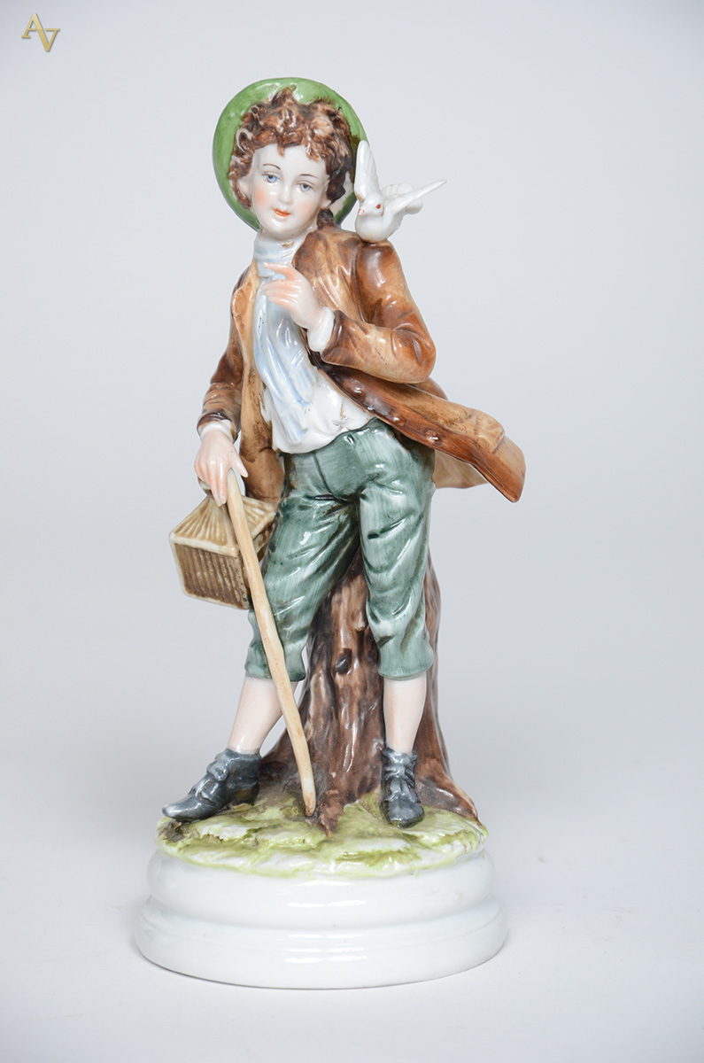 Estatueta de porcelana representando menino com pássaro e bengala... - foto 1 de 2