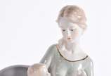 Escultura de porcelana representando mãe com be... - Escultura de porcelana representando mãe com bebê no colo.