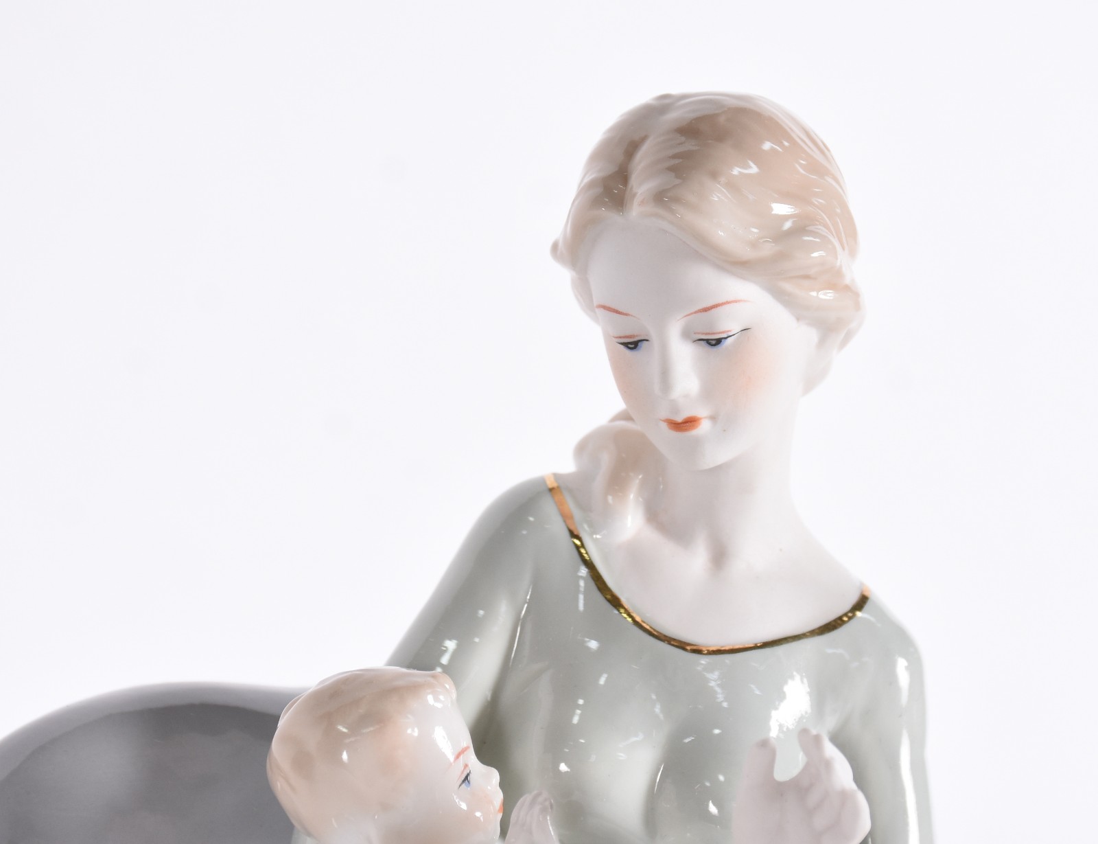 Escultura de porcelana representando mãe com bebê no colo. - foto 2 de 4