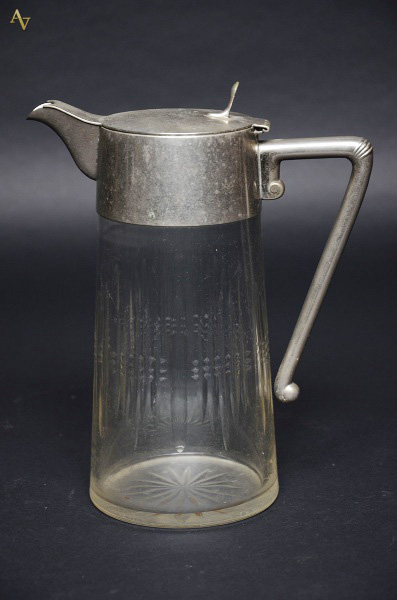 Refresqueira de cristal com alça e gargalo de metal. Altura 26,5 cm
