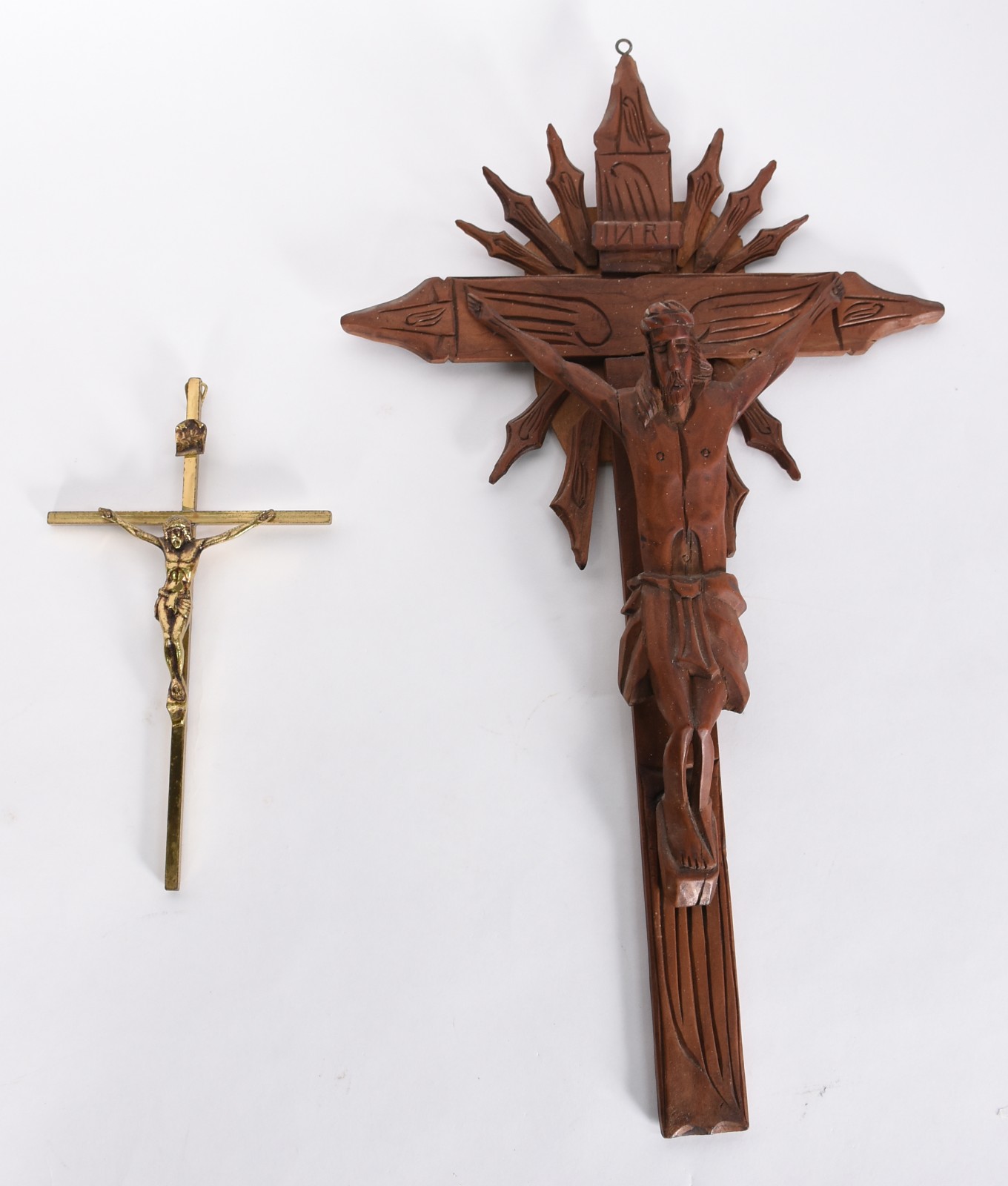 Dois crucifixos sendo um de madeira com Cristo entalhado e outro de... - foto 1 de 4