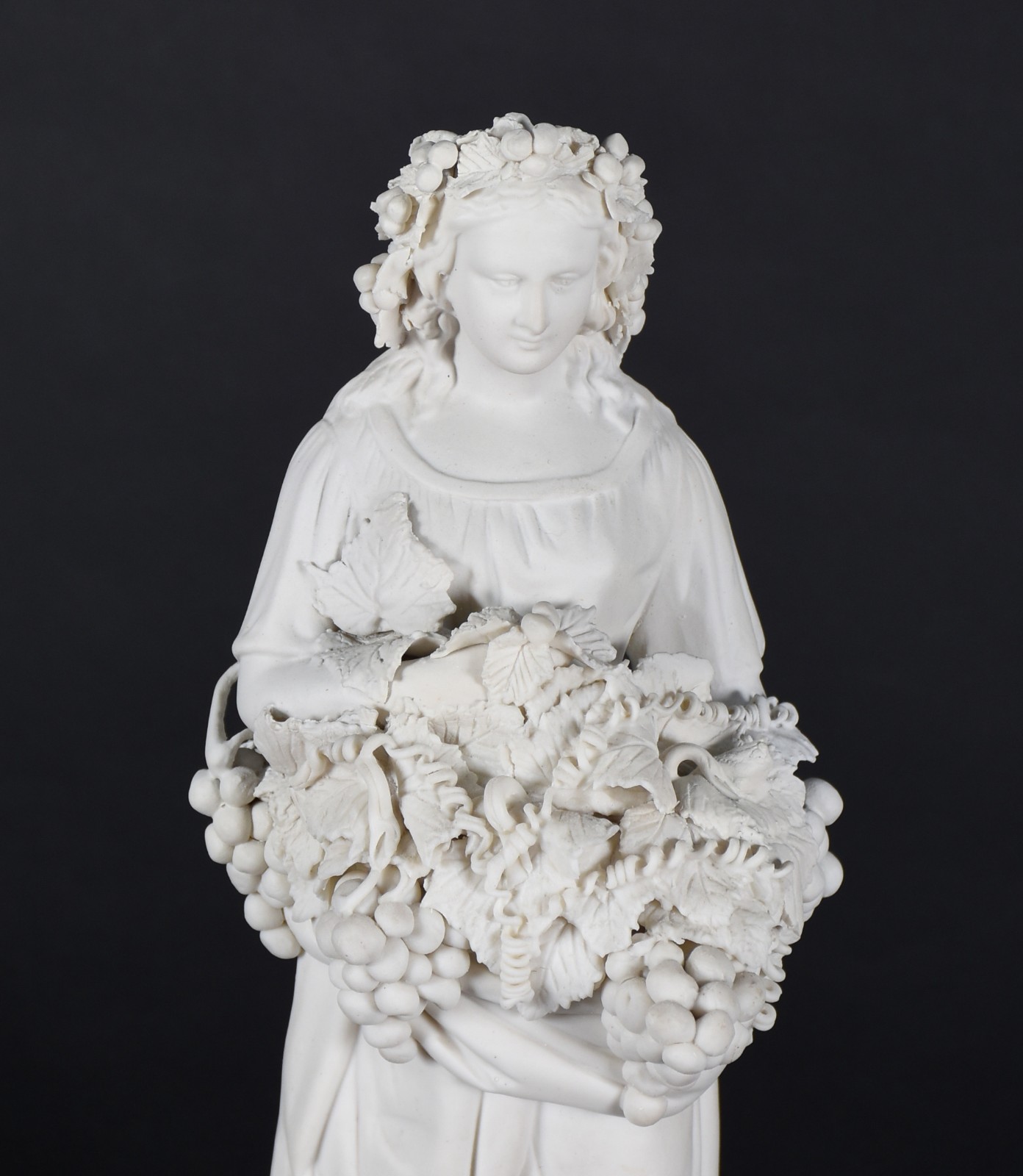 Escultura de biscuit representando dama com cachos de uvas nas mãos. - foto 2 de 4