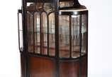 Cristaleira de madeira nobre com laterais arred... - Cristaleira de madeira nobre com laterais arredondadas feitio bombe, vidros bisotados, tampos de mármore, prateleira interna de vidro com fundo ...