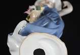 Escultura de porcelana policromada representand... - Escultura de porcelana policromada representando dama com cesto de flores.
