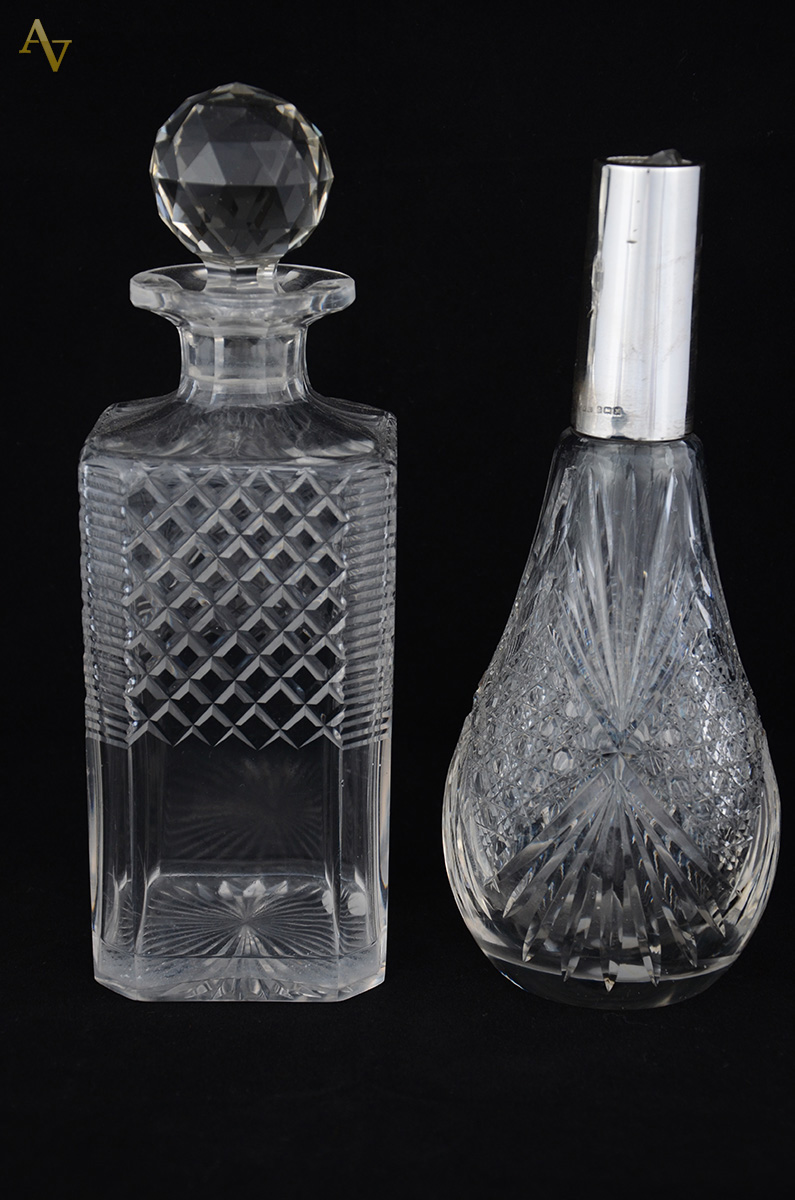 Duas garrafas de cristal lapidado, uma com gargalo de prata inglesa...