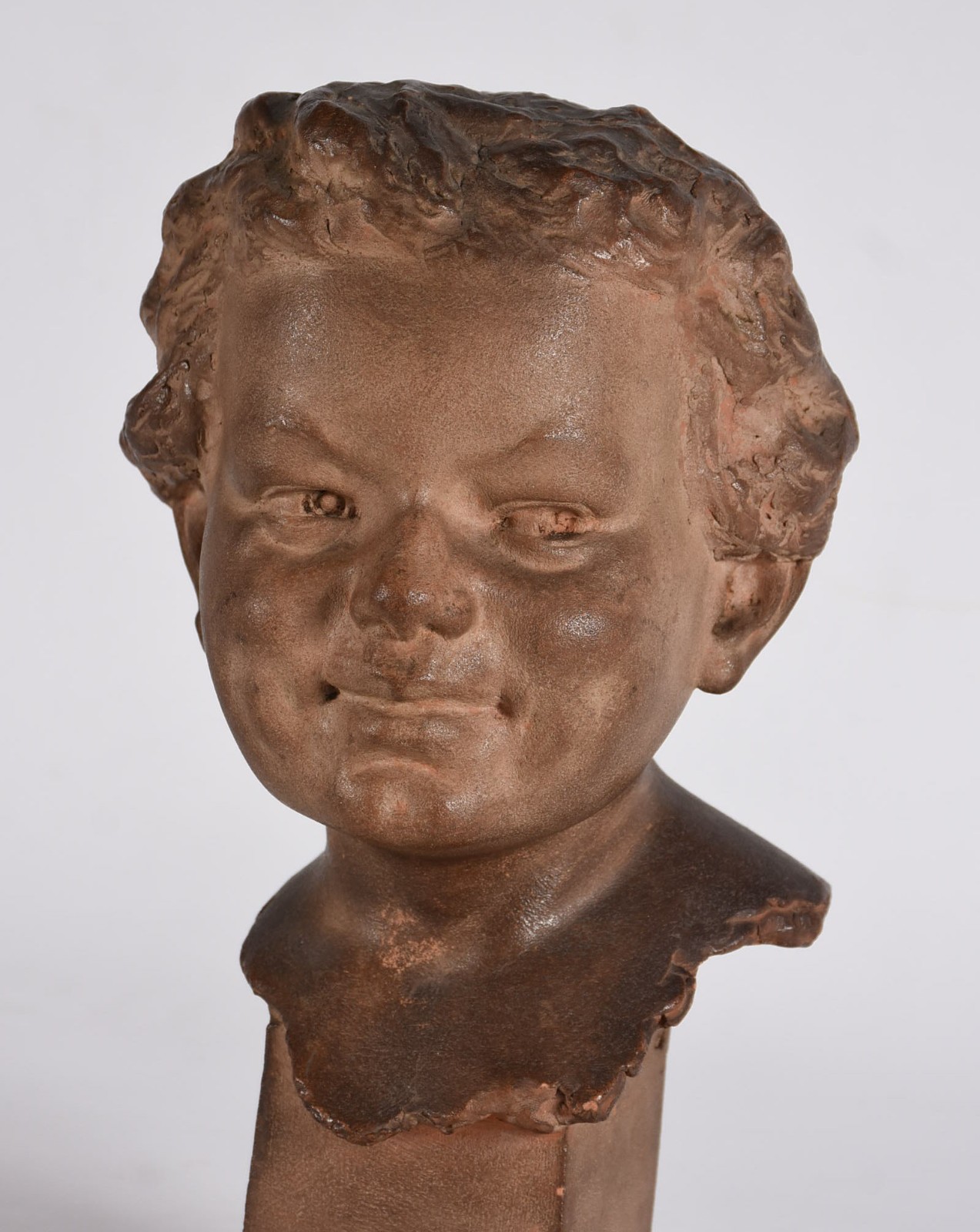 Duas peças, sendo: busto de barro cozido representando menino e caixa... - foto 2 de 10