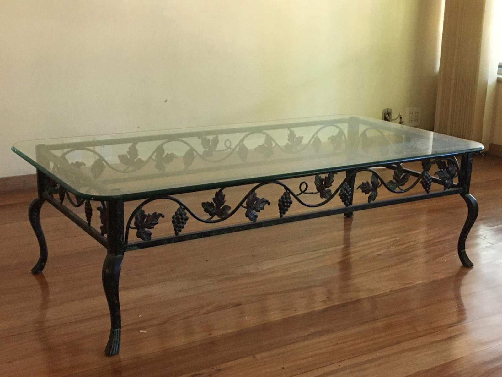 Mesa de centro com base de metal e tampo de vidro com quinas... - foto 1 de 3