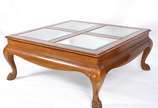 Mesa de centro de madeira nobre (lascada em uma... - Mesa de centro de madeira nobre (lascada em uma das bordas), tampo dividido em quatro tampos de vidro bisotado, saia recortada e pés de garra. P...