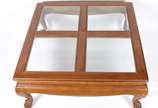 Mesa de centro de madeira nobre (lascada em uma... - Mesa de centro de madeira nobre (lascada em uma das bordas), tampo dividido em quatro tampos de vidro bisotado, saia recortada e pés de garra. P...