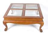 Mesa de centro de madeira nobre (lascada em uma... - Mesa de centro de madeira nobre (lascada em uma das bordas), tampo dividido em quatro tampos de vidro bisotado, saia recortada e pés de garra. P...