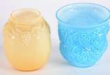 Duas peças de vidro leitoso trabalhado em relev... - Duas peças de vidro leitoso trabalhado em relevo, sendo cachepot na cor azul e vaso amarelo com cachos de uvas.
