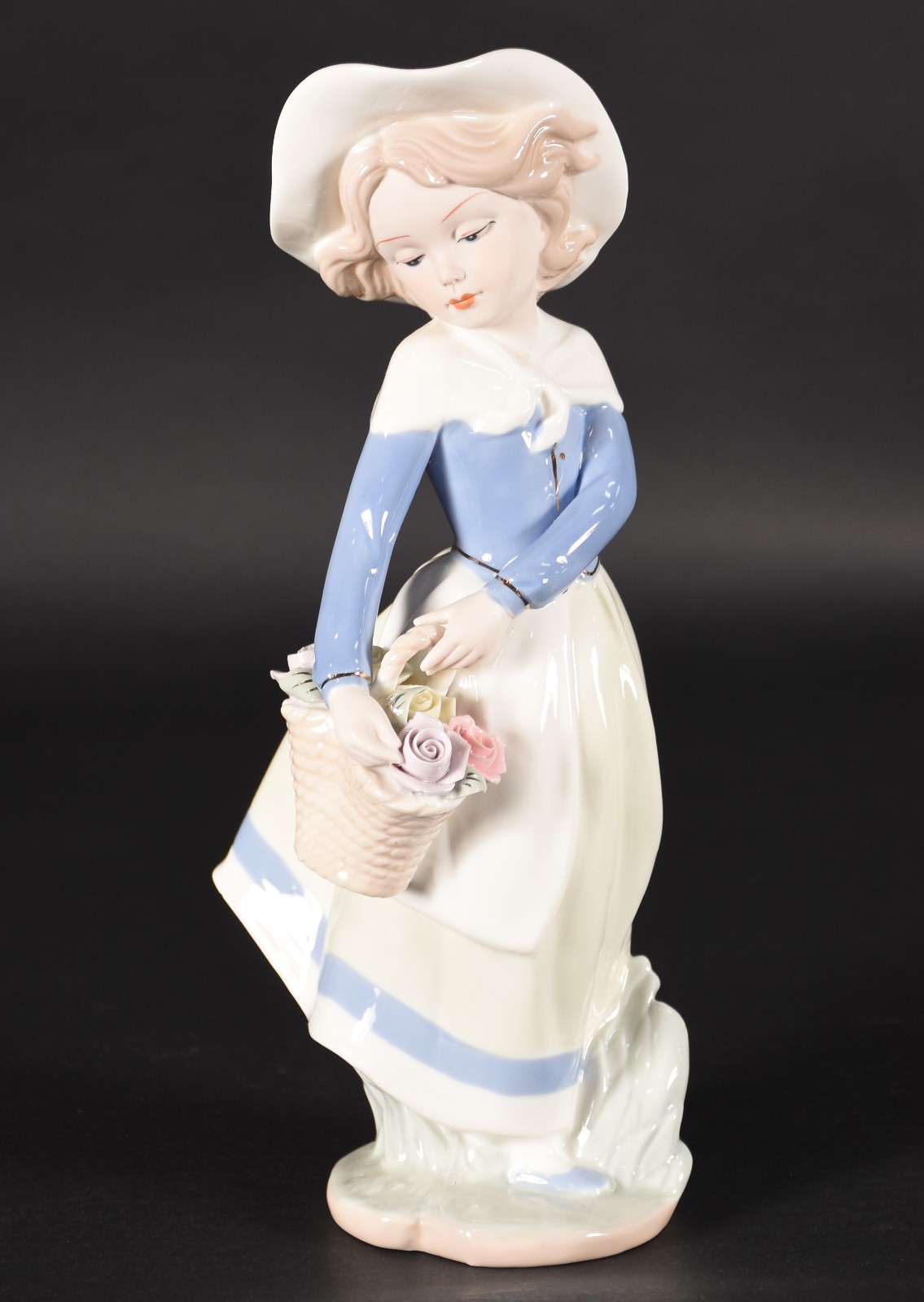 Estatueta de porcelana policromada representando menina com cesto de... - foto 1 de 4