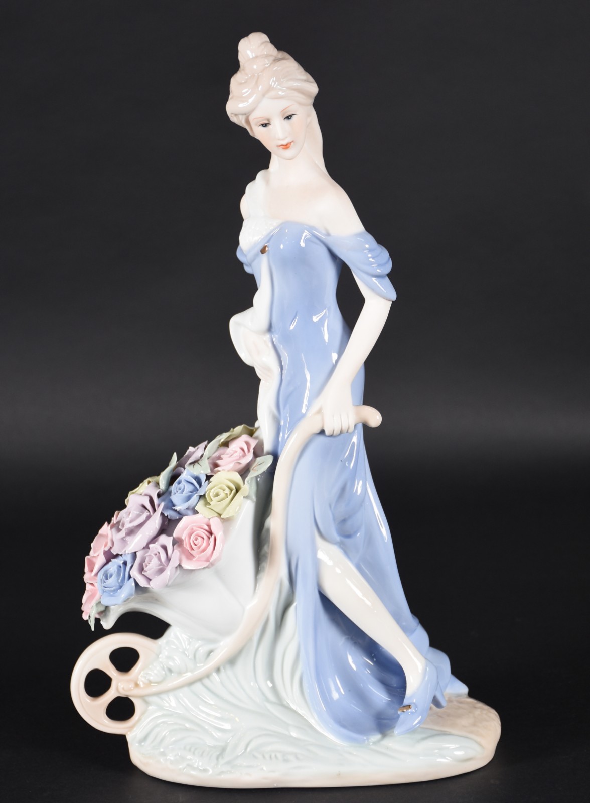 Estatueta de porcelana policromada representando dama com carrinho de... - foto 1 de 4
