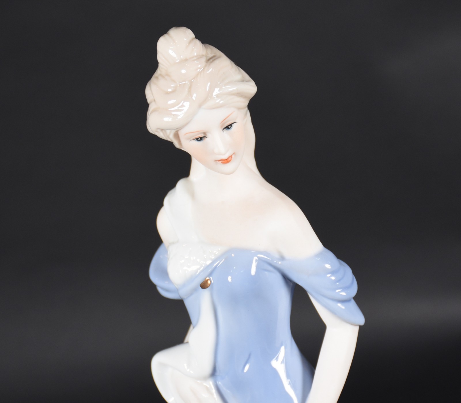Estatueta de porcelana policromada representando dama com carrinho de... - foto 2 de 4