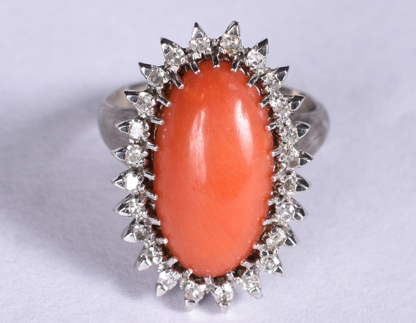 Anel em platina com coral oval, cabochon com 24 brilhantes em volta... - foto 1 de 3