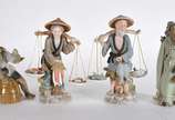 Quatro estatuetas de porcelana, sendo 2 represe... - Quatro estatuetas de porcelana, sendo 2 representando casal com balanças nas costas com peixes e legumes em policromia Seizan e 2 representando ...