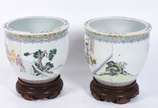 Par de cachepots/aquário de porcelana oriental ... - Par de cachepots/aquário de porcelana oriental decorados com figuras de gueixas em policromia e ideogramas. Bases de madeira.