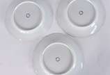 Três pratos de porcelana europeia monogramada, ... - Três pratos de porcelana europeia monogramada, dois deles decorados com figuras femininas e o terceiro com figura de peixe em policromia, bordas...