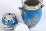 Samovar de porcelana azul turquesa com flores e... - Samovar de porcelana azul turquesa com flores em policromia e frisos realçados em dourado, base vazada para colocação de vela para aquecer o chá...