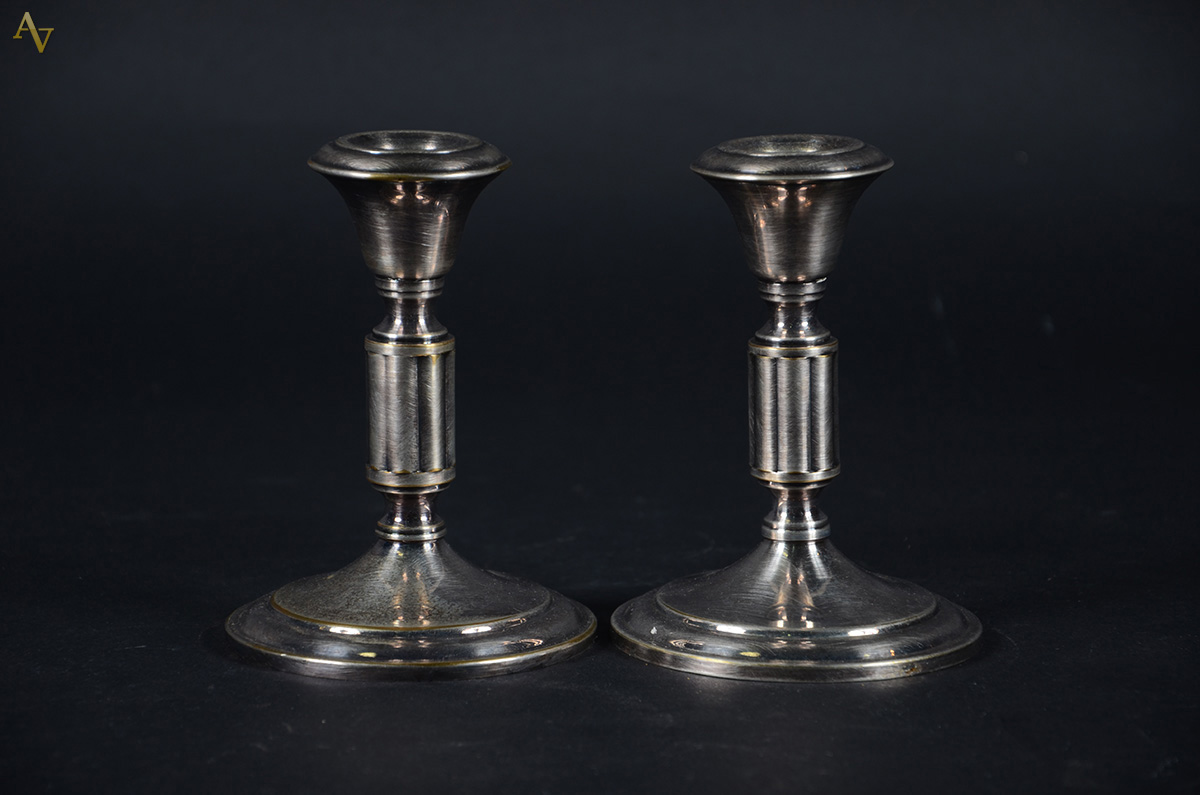Par de castiçais em metal prateado. Altura: 14 cm
