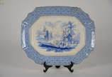 Travessa em faiança azul e branca feitio oitava... - Travessa em faiança azul e branca feitio oitavado, bordas recortadas, centro decorado com figuras e castelo. Med. 40 x 50 cm.