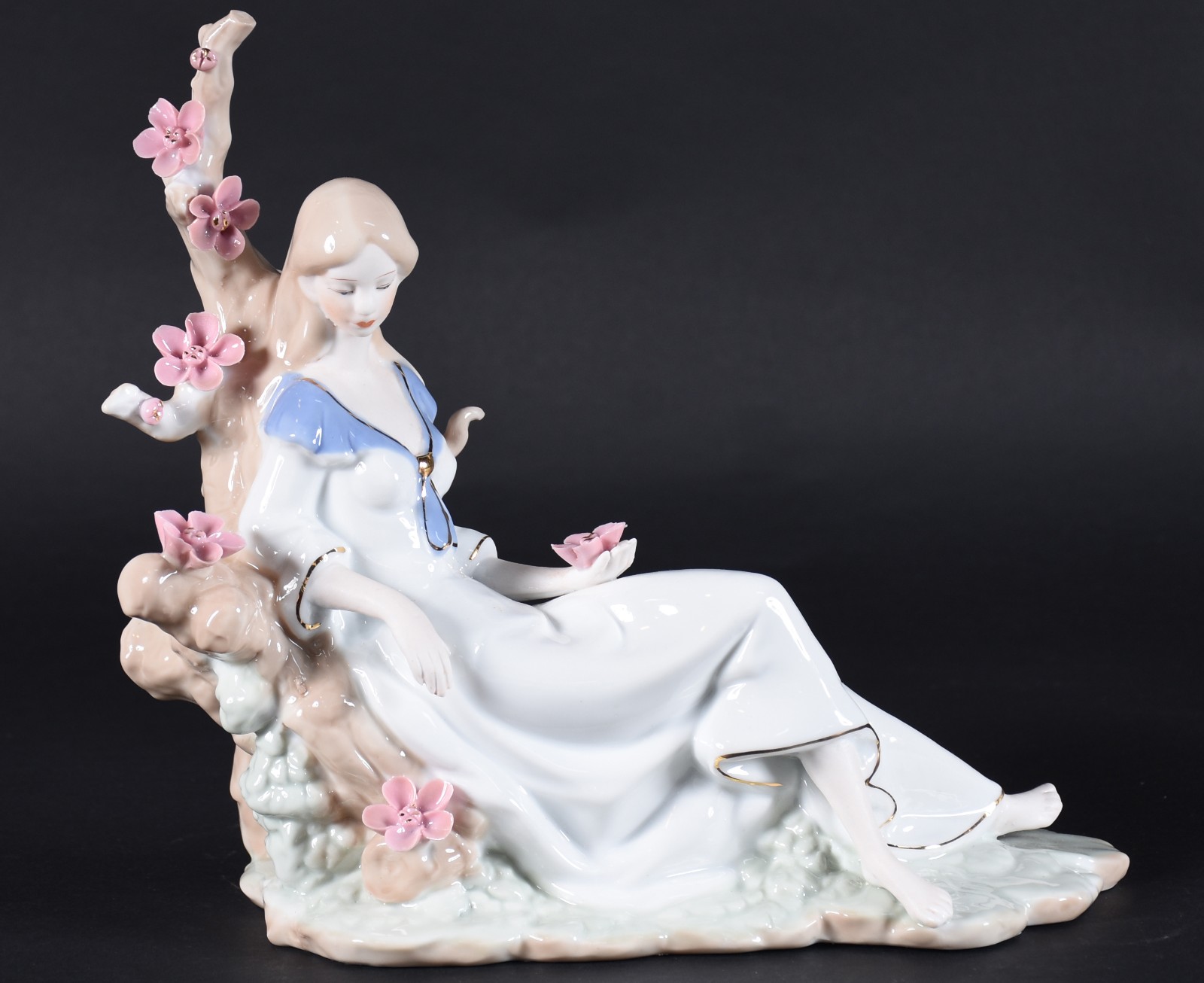 Estatueta de porcelana policromada representando dama recostada com... - foto 1 de 4