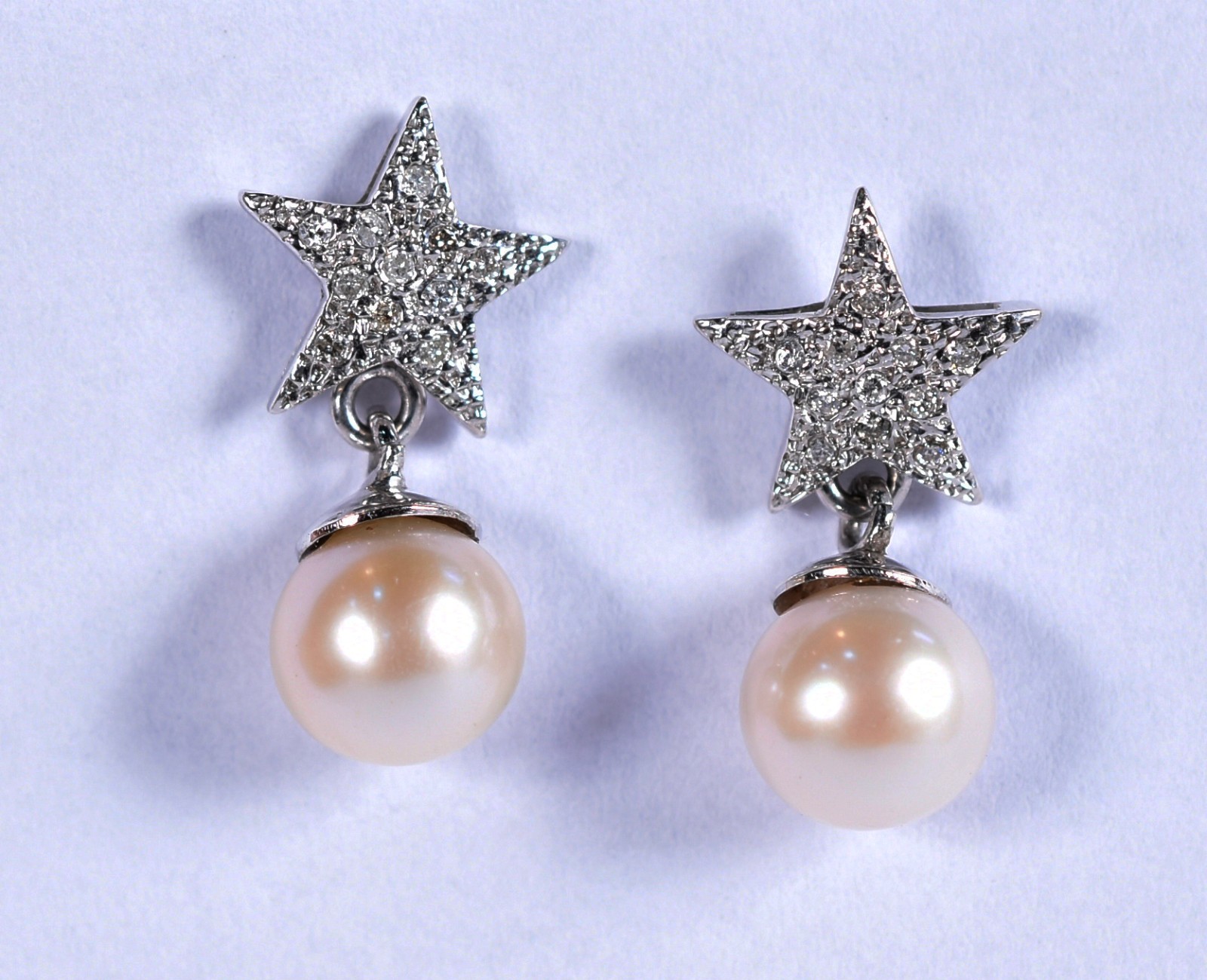 Par de brincos de ouro branco feitio estrelinha com brilhante e 2... - foto 1 de 2