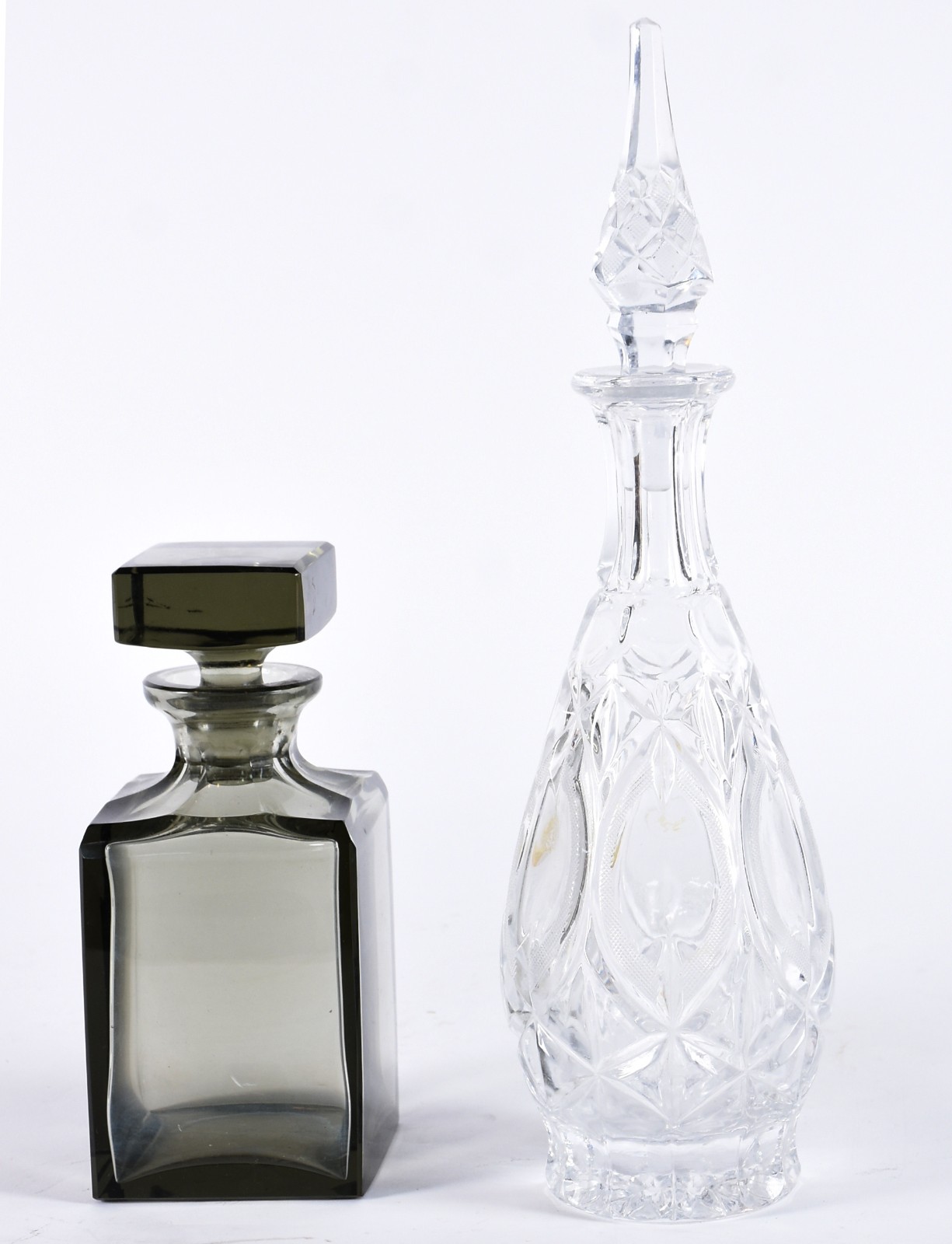 Duas garrafas de cristal, sendo uma fumé quadrada e outra translúcida... - foto 1 de 3