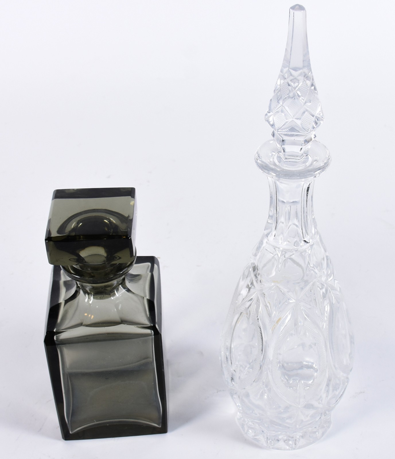 Duas garrafas de cristal, sendo uma fumé quadrada e outra translúcida... - foto 2 de 3