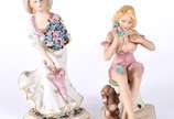 Duas figuras de porcelana policromada, represen... - Duas figuras de porcelana policromada, representando figuras femininas, uma ao telefone e outra com guarda-chuva e bouquet de flores.