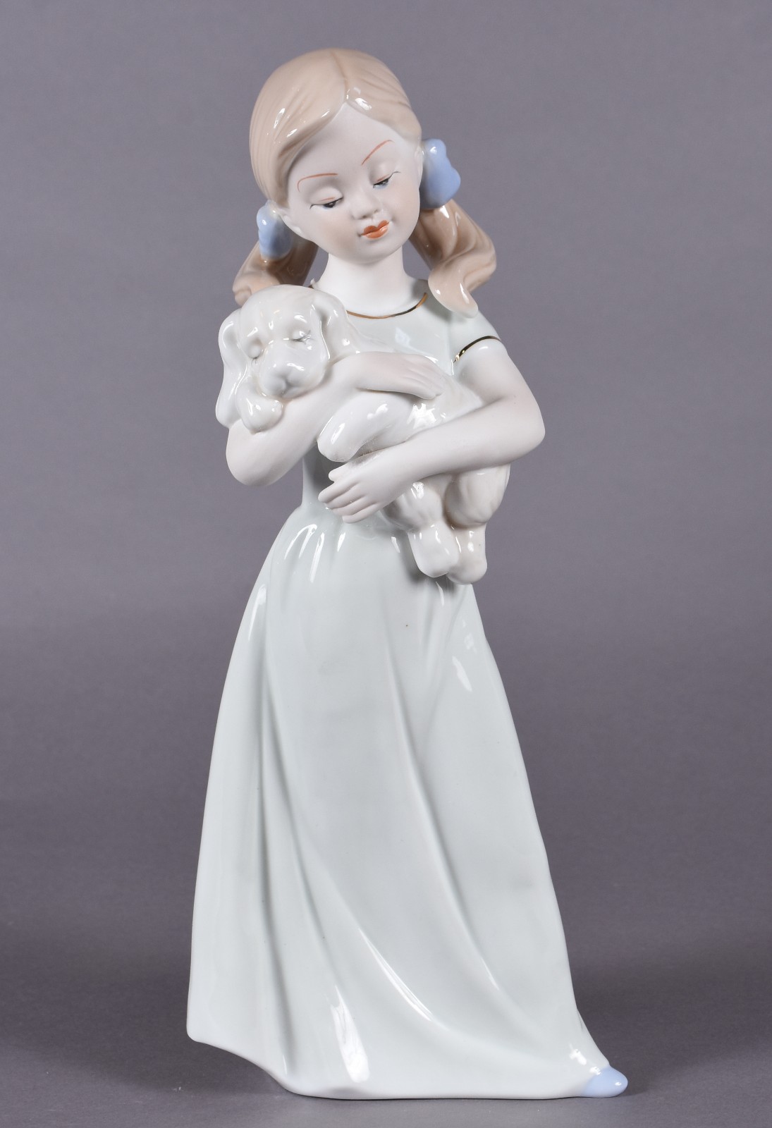 Estatueta de porcelana policromada representando dama com cachorro. - foto 1 de 4