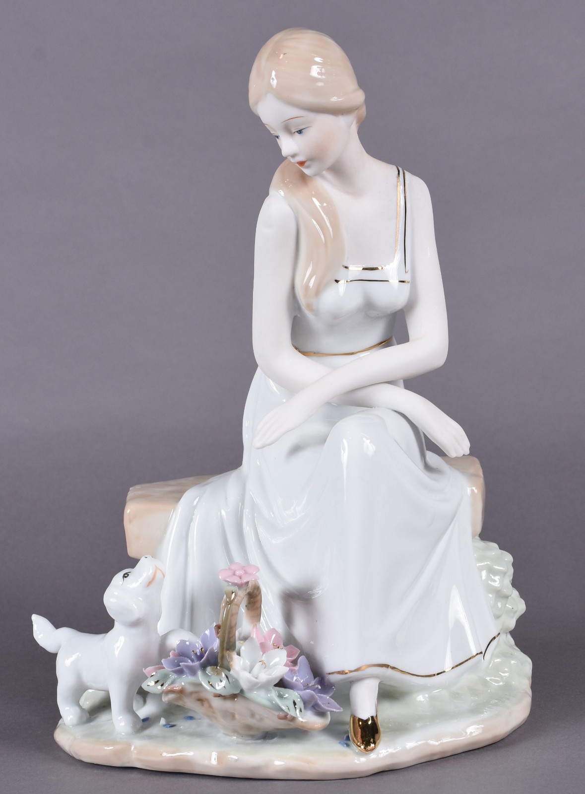 Estatueta de porcelana policromada representando dama com cachorro. - foto 1 de 4