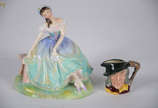 Duas peças de porcelana inglesa policromada, RO... - Duas peças de porcelana inglesa policromada, ROYAL DOULTON, sendo uma figura feminina repres. "Giselle" (alt.15 cm) e uma pequena caneca...