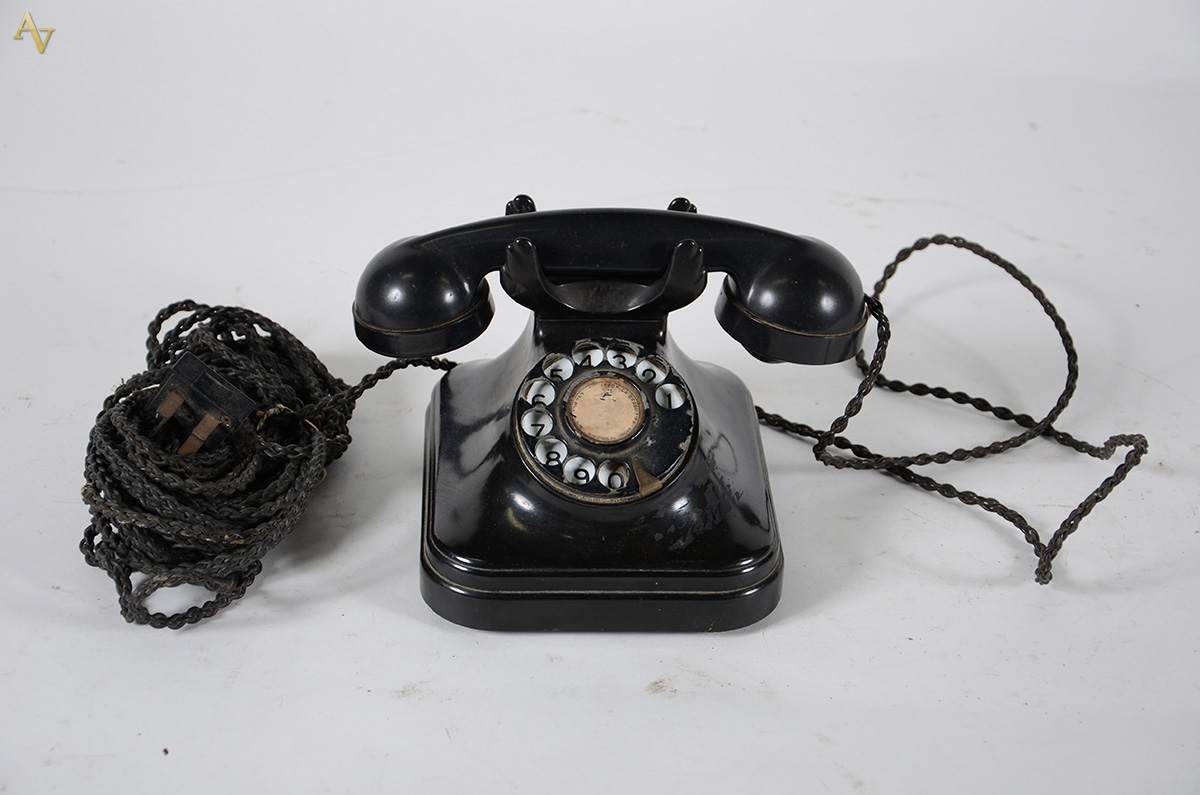 Antigo aparelho telefônico de baquelite preta.