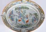 Travessa oval em porcelana chinesa, decorada em... - Travessa oval em porcelana chinesa, decorada em esmaltes policromados no estilo da Famille Verte. Borda em gregas e faixa com reservas sobre fun...