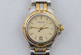 GUCCI - Relógio com pulseira em aço e ouro. Mos... - GUCCI - Relógio com pulseira em aço e ouro. Mostrador claro, com datador. Resistência à água: até 3 atmosferas. Fabricação Suíça. Marcas da grif...