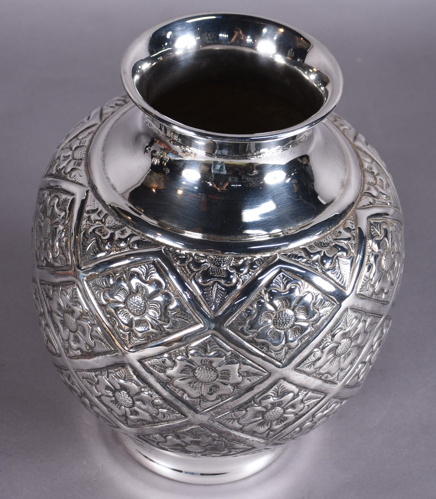 Vaso decorativo de metal prateado com flores em relevo, feitio bojudo. - foto 2 de 2