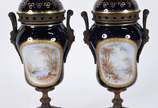Par de ânforas em porcelana francesa de Sèvres,... - Par de ânforas em porcelana francesa de Sèvres, "Chateau des Tuileries", na cor azul cobalto e paisagens policromadas em reserva com realces dou...