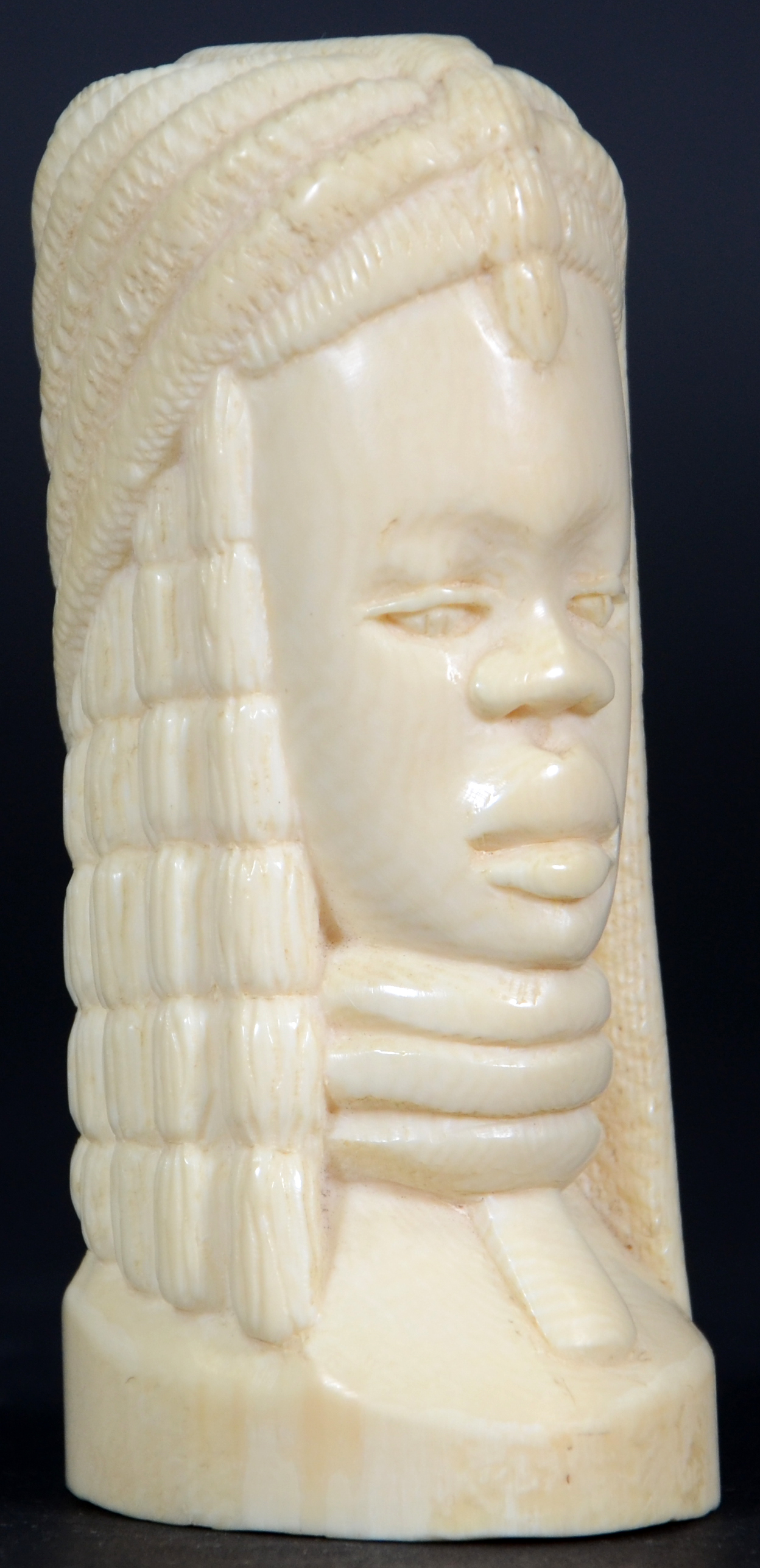 Estatueta de marfim representando busto feminino.