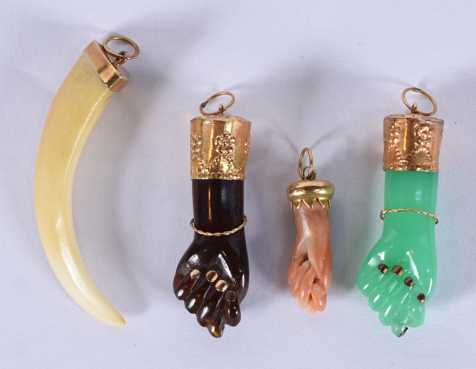 Quatro berloques, sendo: 3 figas e dente com terminações de ouro... - foto 1 de 4