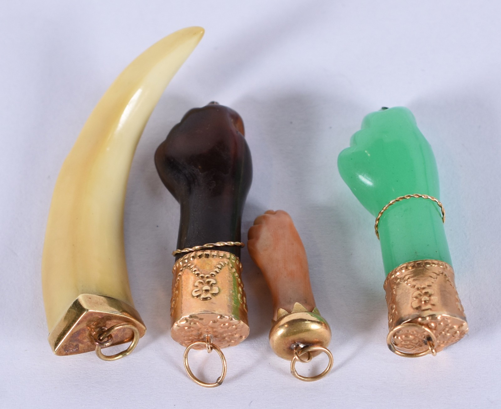 Quatro berloques, sendo: 3 figas e dente com terminações de ouro... - foto 3 de 4