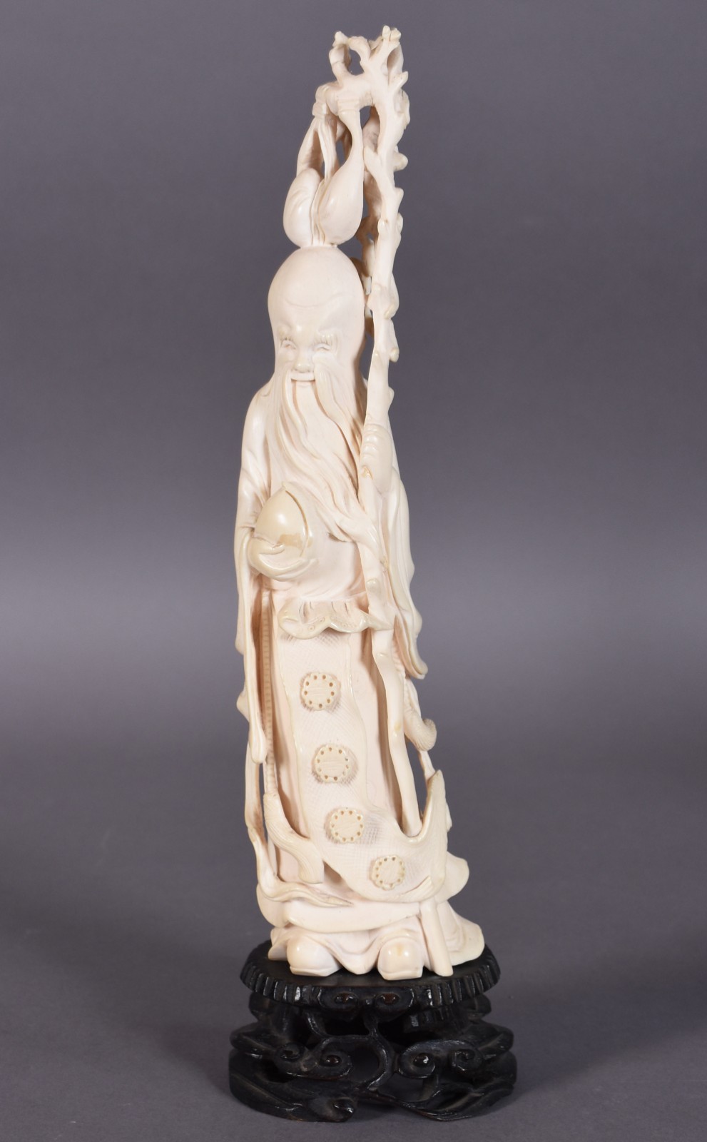 Escultura de marfim representando sábio com cajado e pêssego, fruto... - foto 1 de 4