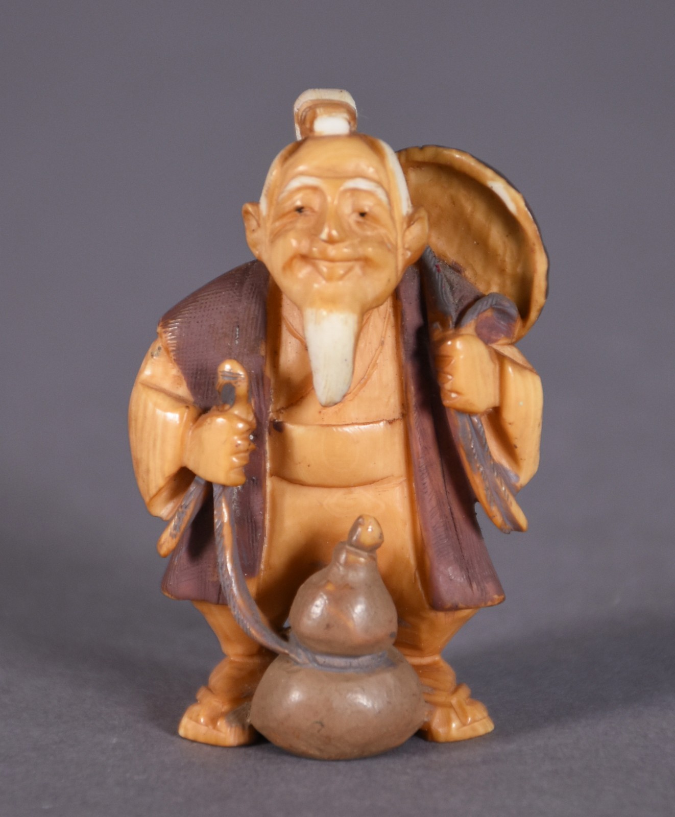 Netsuke de marfim representando figura com ventarola e cântaro... - foto 1 de 3
