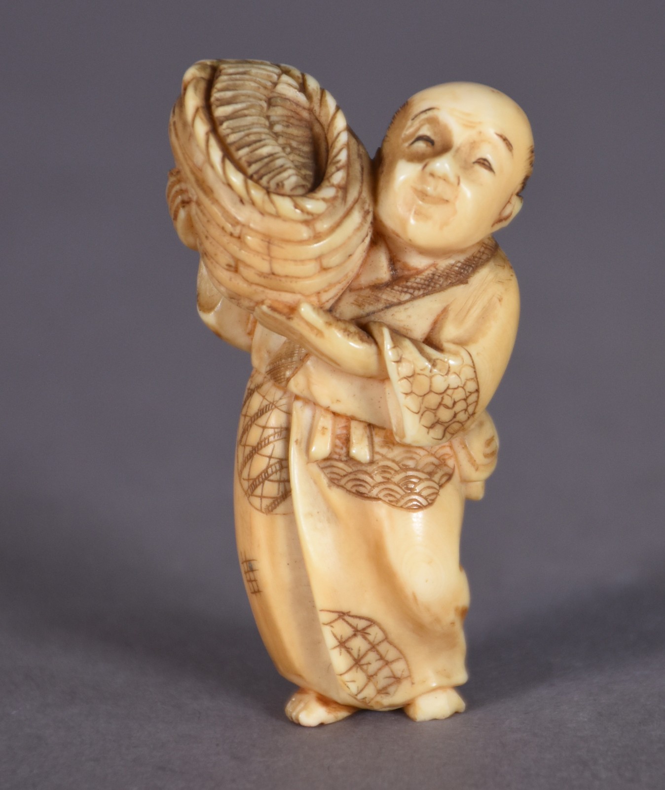 Netsuke de marfim representando figura com cesto. - foto 1 de 3