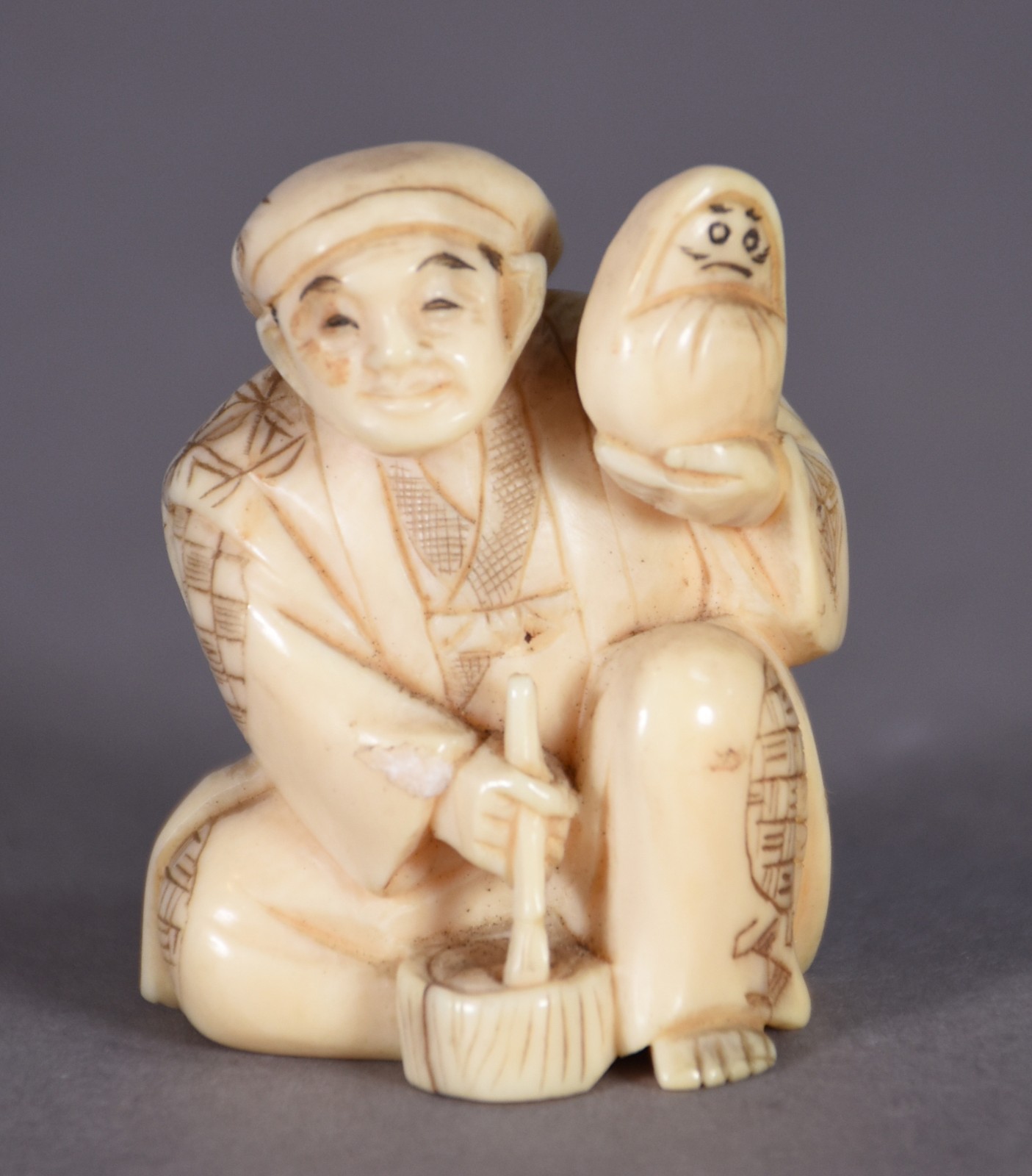 Netsuke de marfim representando figura com boneco. - foto 1 de 3