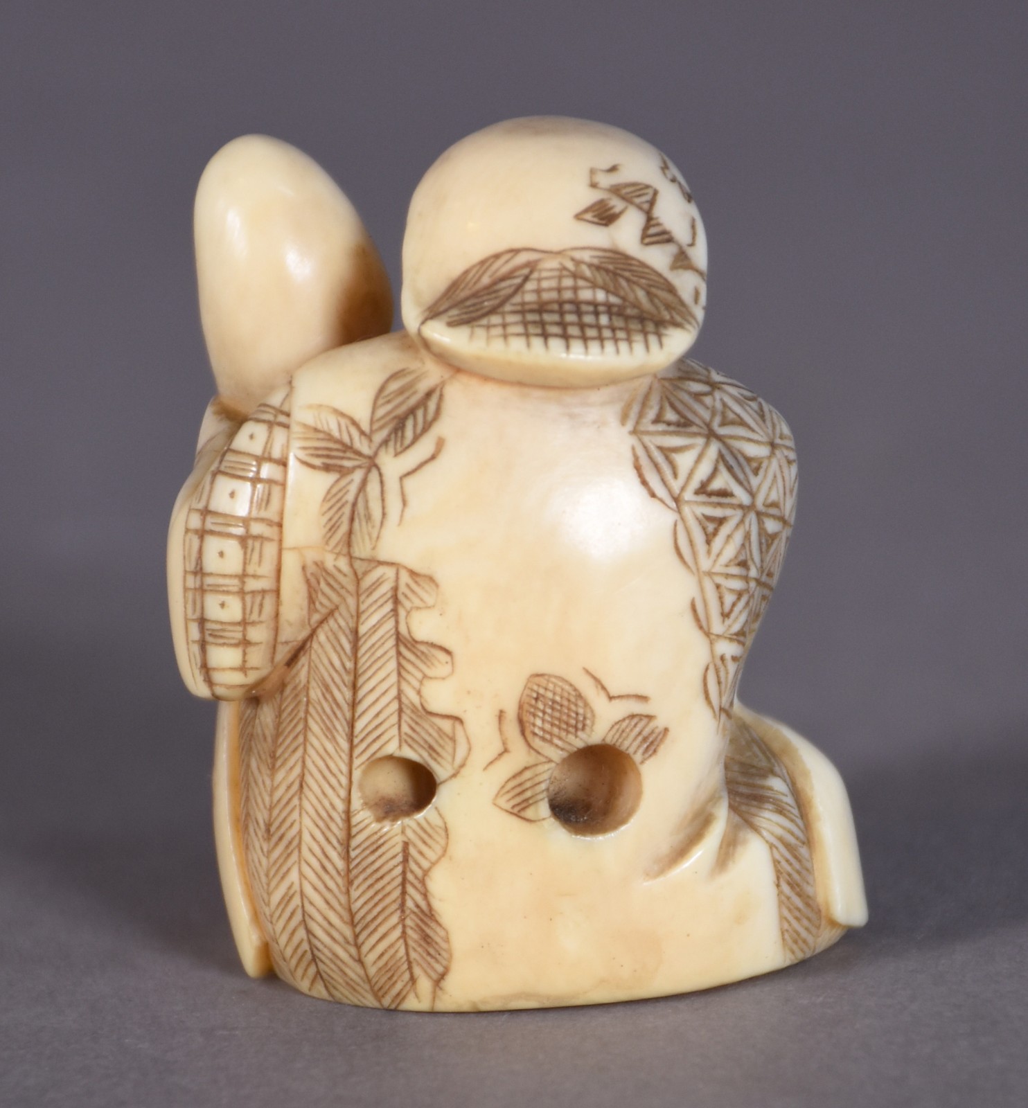 Netsuke de marfim representando figura com boneco. - foto 2 de 3
