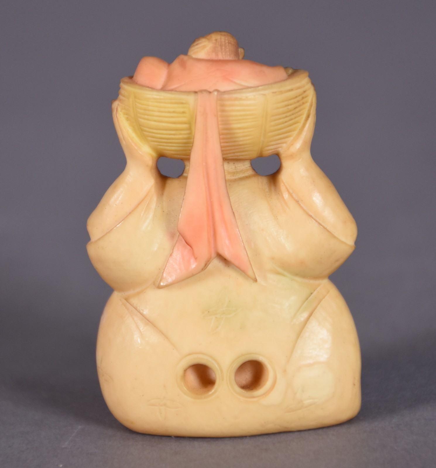 Netsuke de marfim representando figura segurando criança no cesto... - foto 2 de 3