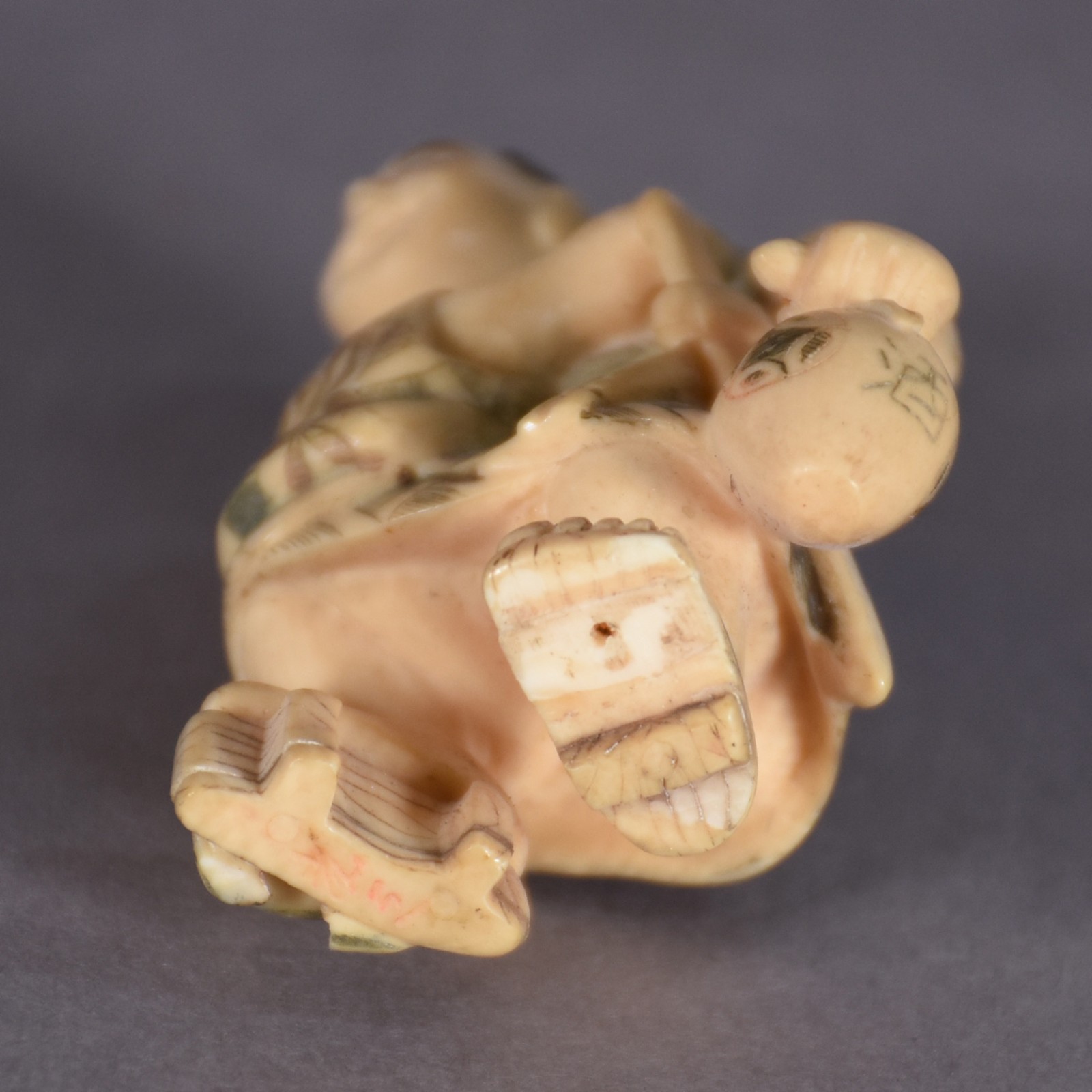Netsuke de marfim policromado representando figura com cantil. - foto 2 de 3